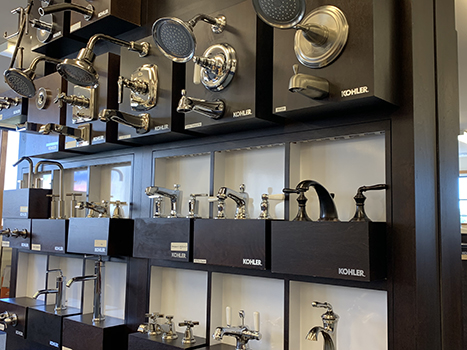 A wall of plumbing and faucet fixtures on display in showroom