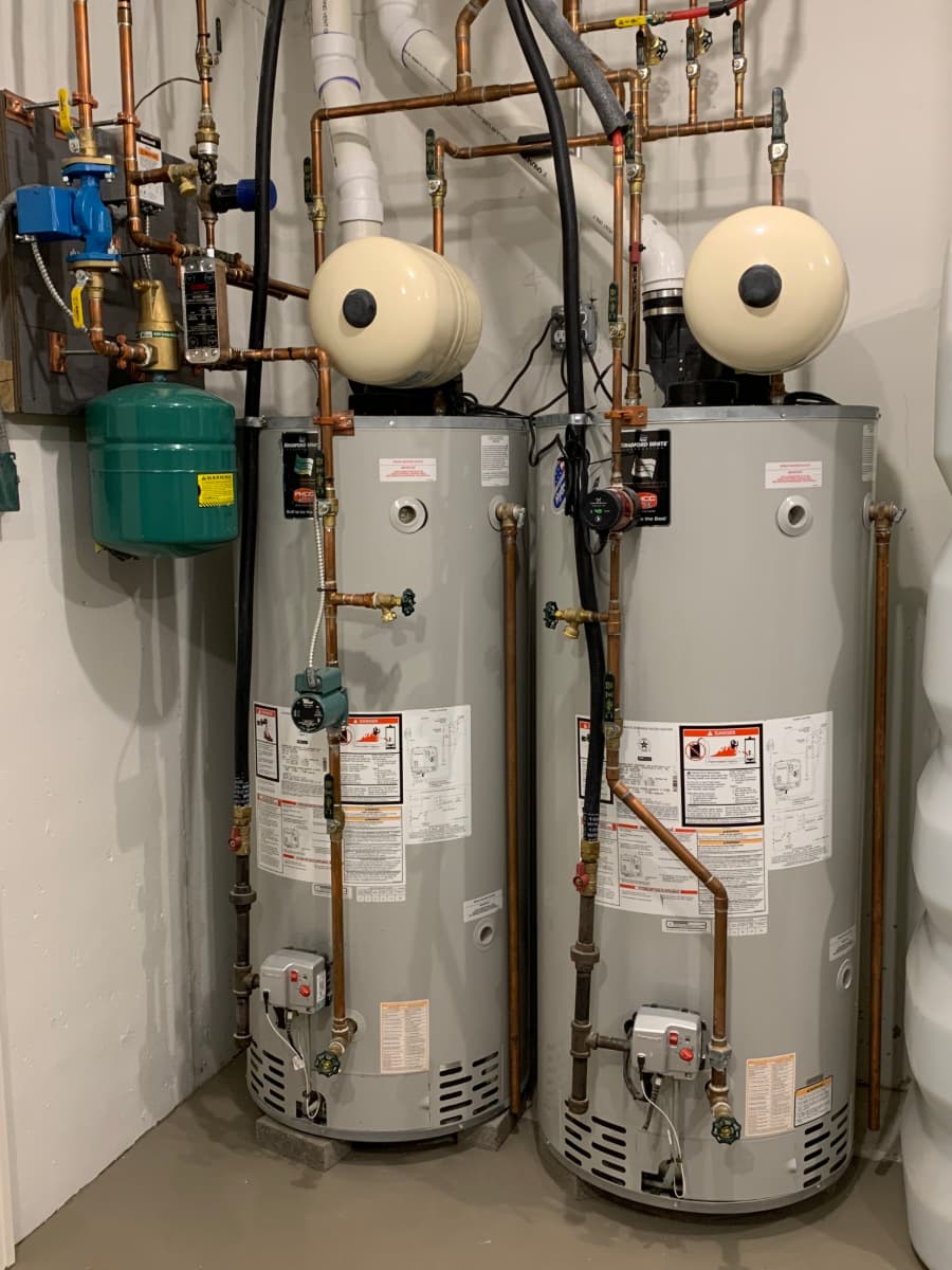 Two hot water heaters side by side in room