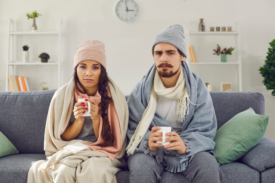 Upset couple with mugs, hats, and scarves